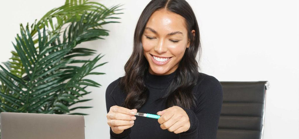 smiling woman with whitening pen